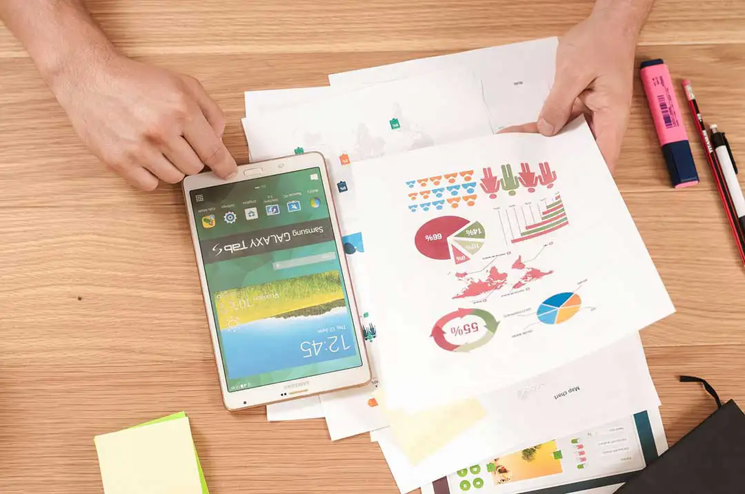 Tablet and charts on a wooden desk.